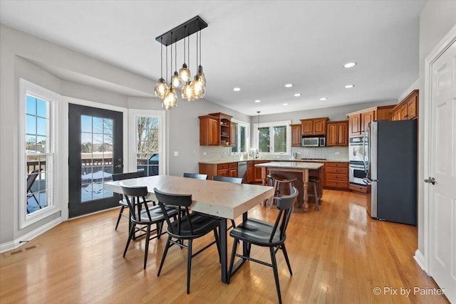 dining room with light wood-type flooring, recessed lighting, and a chandelier