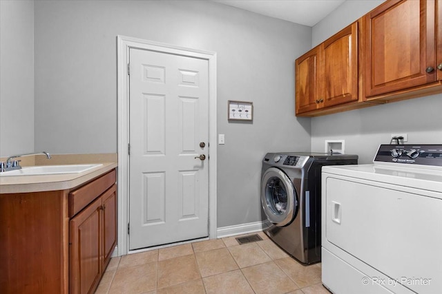 clothes washing area with cabinet space, independent washer and dryer, light tile patterned floors, and baseboards