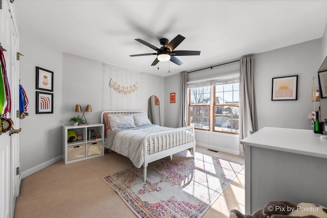 bedroom featuring light carpet, baseboards, and a ceiling fan
