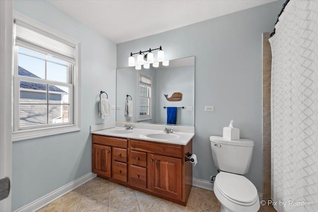 bathroom featuring toilet, double vanity, tile patterned flooring, and baseboards
