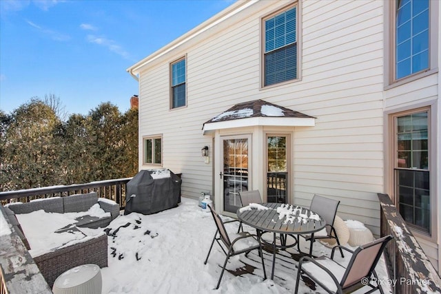 snow covered deck with a grill