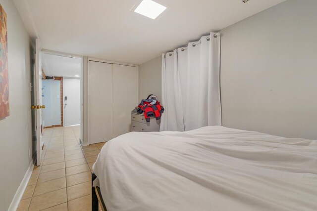 3809 N Kenmore Ave, Chicago, IL 60613 - bedroom featuring light tile patterned floors, a closet, and baseboards
