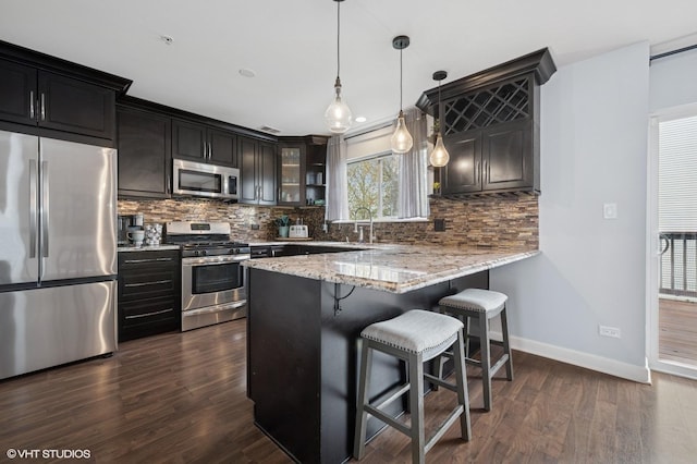 684 Diamond Pointe Dr, Mundelein, IL 60060 - kitchen with stainless steel appliances, decorative backsplash, glass insert cabinets, baseboards, and a kitchen breakfast bar