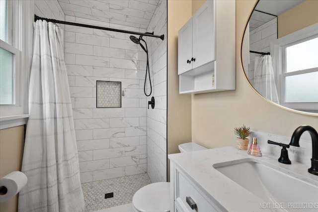 20 S Cambridge Dr, Geneva, IL 60134 - bathroom featuring healthy amount of natural light, a tile shower, vanity, and toilet