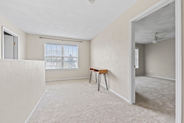 spare room featuring carpet flooring, baseboards, and ceiling fan