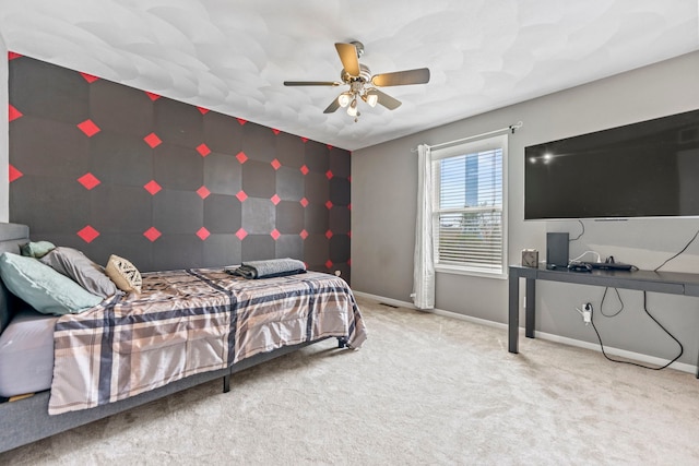 bedroom featuring an accent wall, baseboards, carpet flooring, and ceiling fan