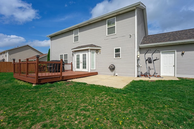 back of property with french doors, a wooden deck, a lawn, and a patio