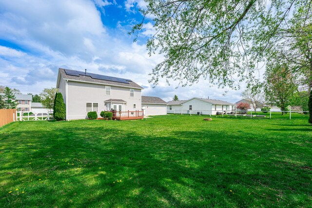 back of property featuring a deck and solar panels