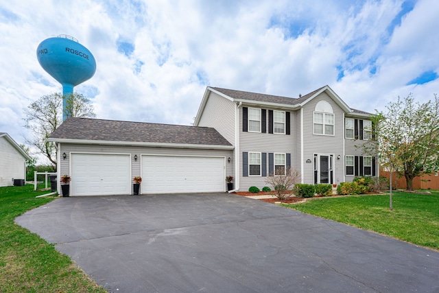 colonial inspired home featuring asphalt driveway, a front yard, an attached garage, and central air condition unit