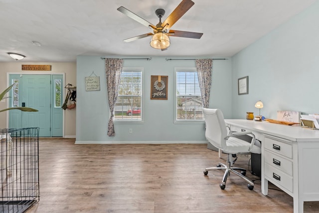office area with wood finished floors, a ceiling fan, and baseboards