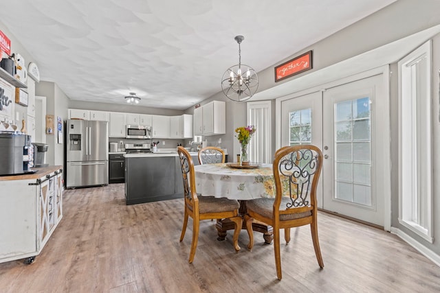 dining room featuring light wood-type flooring and a chandelier