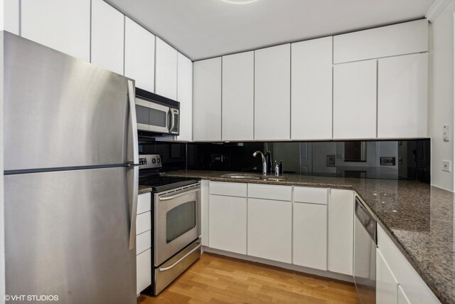 30 E Huron St Unit 1110, Chicago, IL 60611 - kitchen with appliances with stainless steel finishes, a sink, dark stone counters, and white cabinets