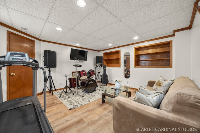 workout room featuring crown molding, baseboards, wood finished floors, and recessed lighting
