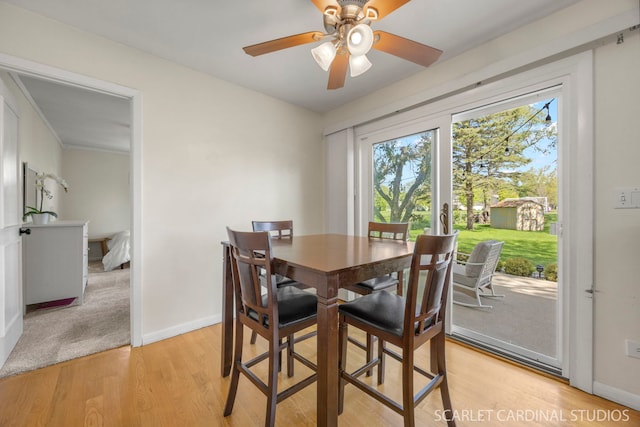 dining area with light wood finished floors, baseboards, and ceiling fan