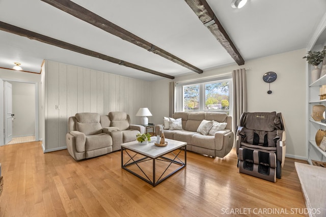 living area featuring beam ceiling and light wood-style flooring