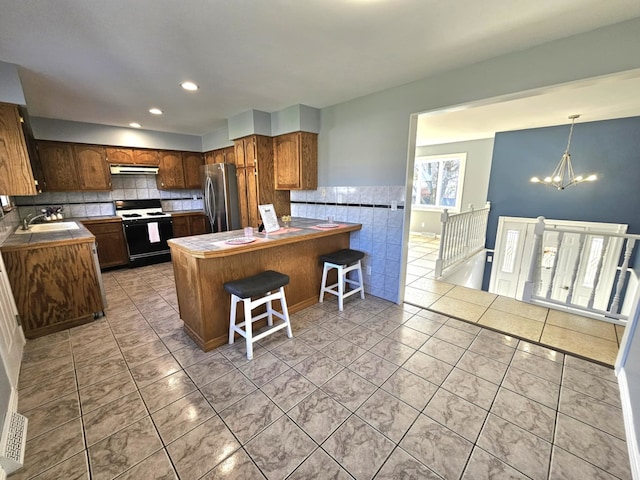 23530 W Gagne Ln, Plainfield, IL 60586 - kitchen with range, freestanding refrigerator, a chandelier, a peninsula, and a sink