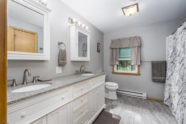 2651 E 2900 N Rd, Ancona, IL 61311 - bathroom featuring a baseboard radiator, double vanity, toilet, and baseboards