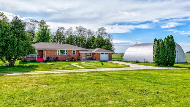2651 E 2900 N Rd, Ancona, IL 61311 - view of front of home with driveway, a garage, a front lawn, brick siding, and an outbuilding