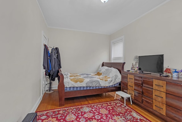 bedroom featuring ornamental molding and light wood-type flooring