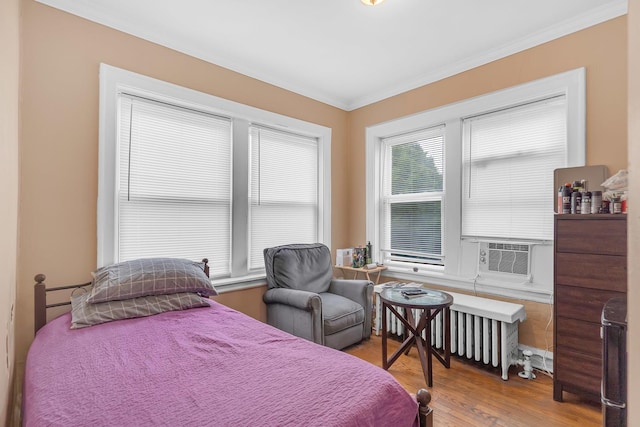 bedroom with wood finished floors and crown molding