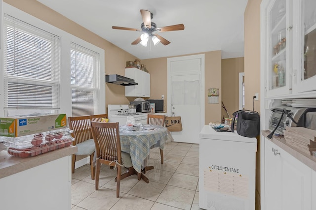 dining space with a ceiling fan and light tile patterned flooring