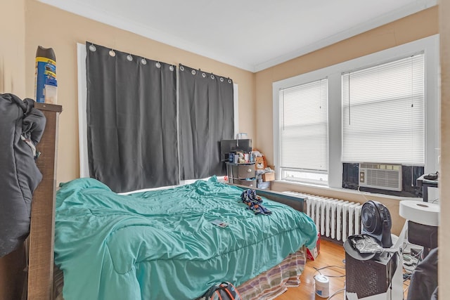 bedroom featuring radiator and wood finished floors