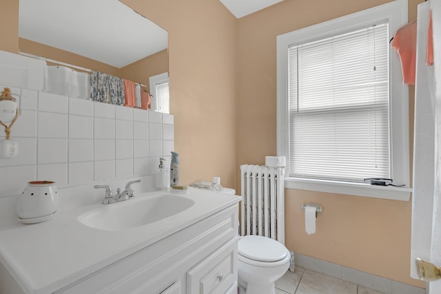 bathroom with radiator heating unit, tile patterned flooring, toilet, and healthy amount of natural light