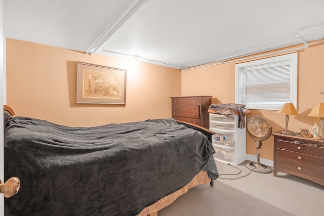 bedroom with concrete flooring and baseboards