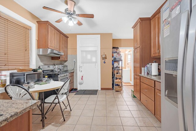 6712 N Artesian Ave, Chicago, IL 60645 - kitchen with appliances with stainless steel finishes, under cabinet range hood, a ceiling fan, light tile patterned floors, and decorative backsplash
