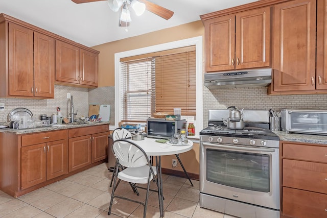 kitchen featuring stainless steel appliances, under cabinet range hood, ceiling fan, and light tile patterned flooring