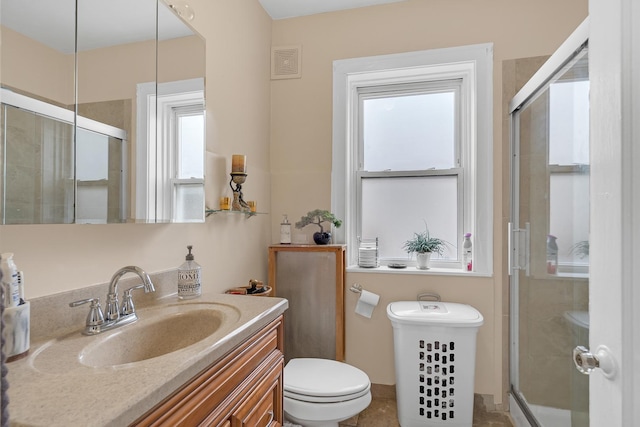 full bathroom featuring a shower stall, toilet, and vanity