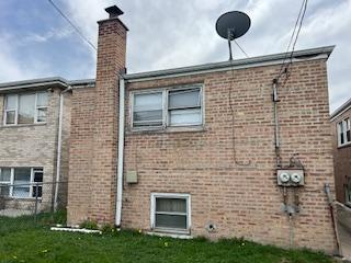 7502 W 64th St, Summit, IL 60501 - view of property exterior with brick siding, a chimney, and a yard