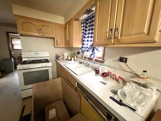 7502 W 64th St, Summit, IL 60501 - kitchen featuring white range with gas stovetop, light countertops, and a sink
