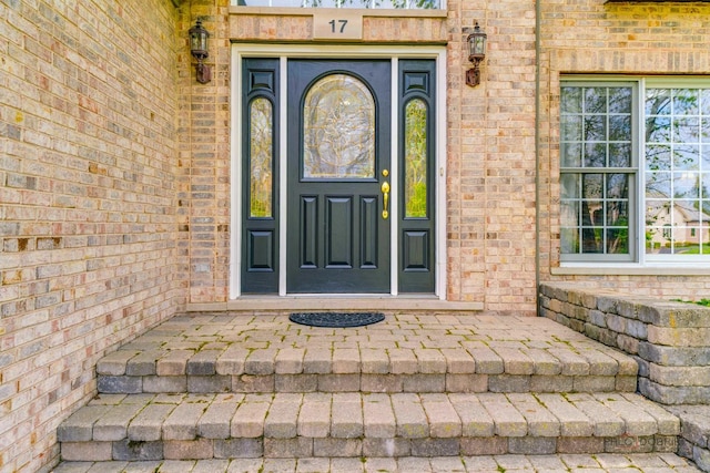 entrance to property featuring brick siding