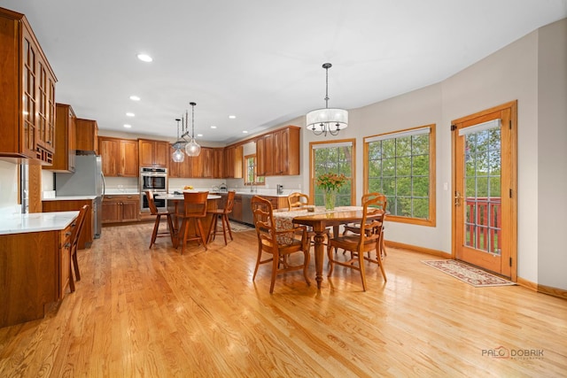 dining area featuring light wood-style flooring, baseboards, recessed lighting, and a chandelier