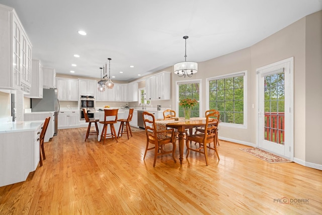 dining area featuring plenty of natural light, light wood-style flooring, recessed lighting, a chandelier, and baseboards