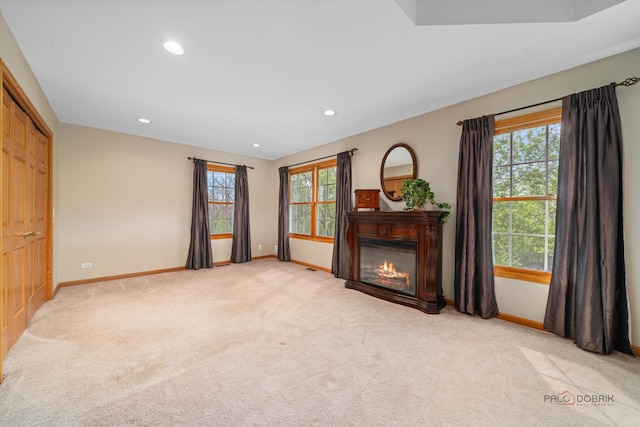 unfurnished living room featuring baseboards, plenty of natural light, and recessed lighting