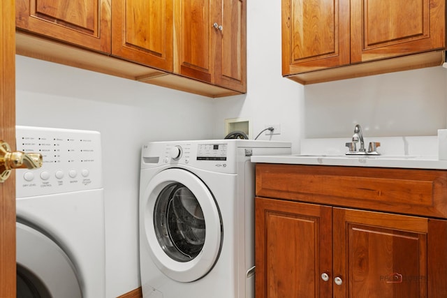 clothes washing area with independent washer and dryer and cabinet space