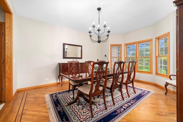 dining room featuring baseboards, a chandelier, and light wood-type flooring