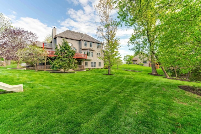 view of green lawn featuring a deck