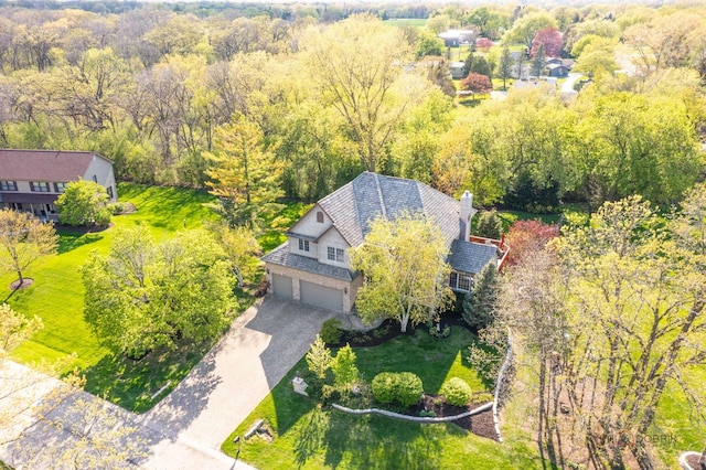 aerial view of property and surrounding area featuring a forest