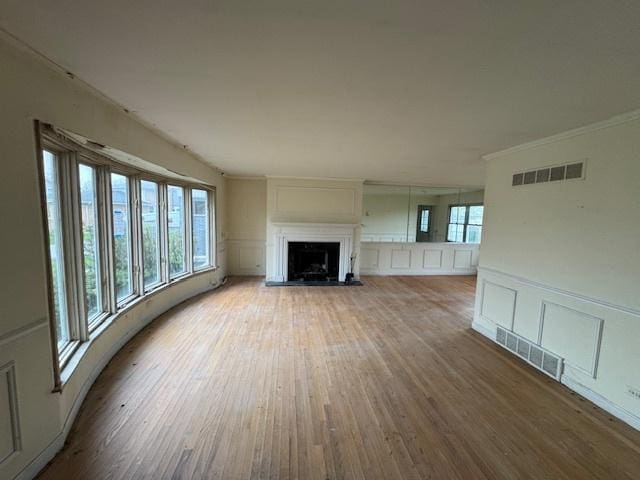 8135 W Rascher Ave, Chicago, IL 60656 - unfurnished living room with a decorative wall, wood finished floors, a fireplace, crown molding, and wainscoting