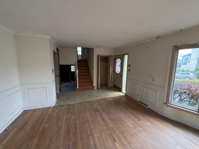 8135 W Rascher Ave, Chicago, IL 60656 - entryway featuring wood finished floors, stairs, plenty of natural light, a decorative wall, and wainscoting