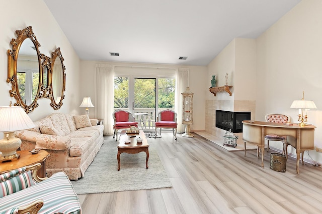 living room with wood finished floors, a fireplace, and baseboards