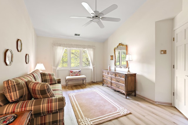 sitting room featuring light wood finished floors, vaulted ceiling, a ceiling fan, and baseboards