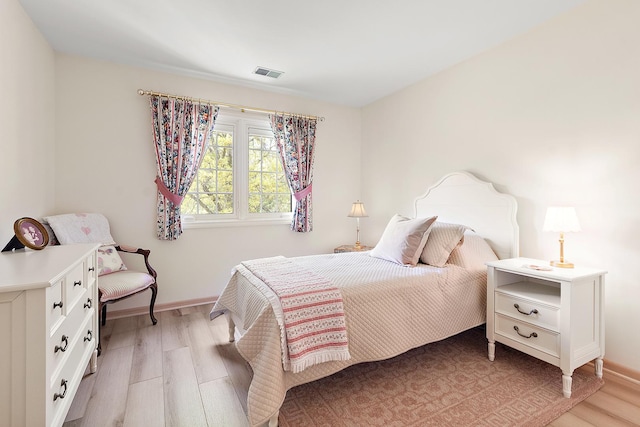 bedroom featuring light wood-style floors and baseboards