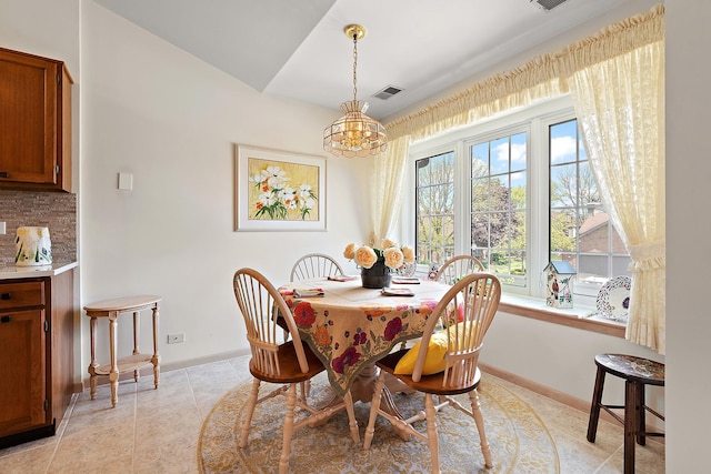 dining room featuring a chandelier and baseboards