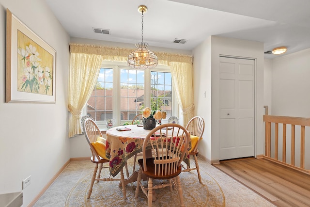 dining room featuring a chandelier, baseboards, and light wood-style flooring