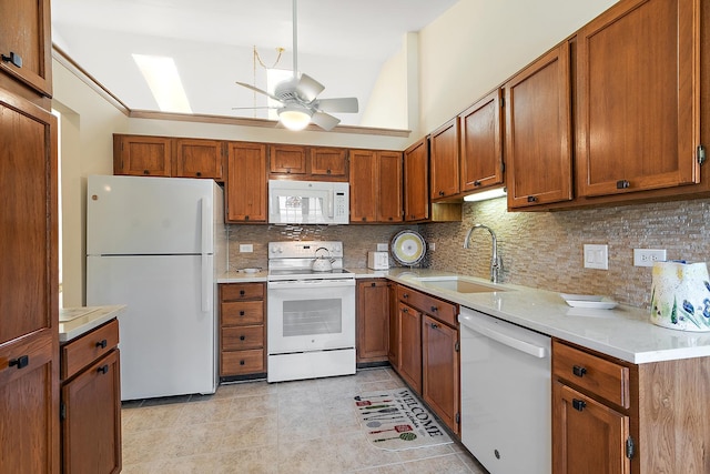 kitchen with white appliances, a sink, a ceiling fan, and brown cabinets