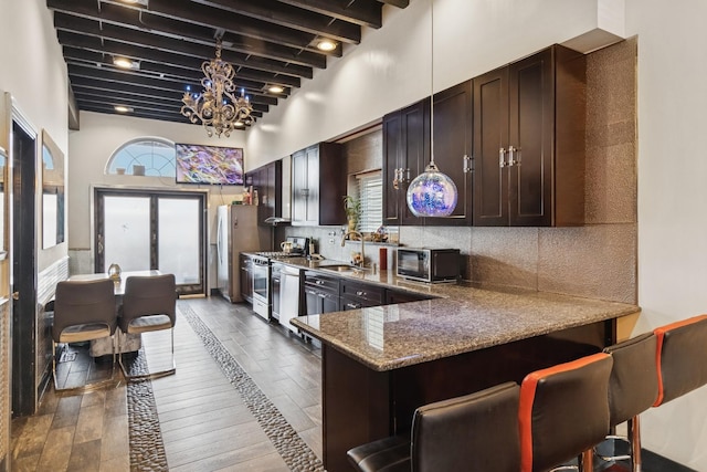 5127 S Artesian Ave, Chicago, IL 60632 - kitchen with beam ceiling, stainless steel appliances, hardwood / wood-style flooring, a chandelier, and backsplash